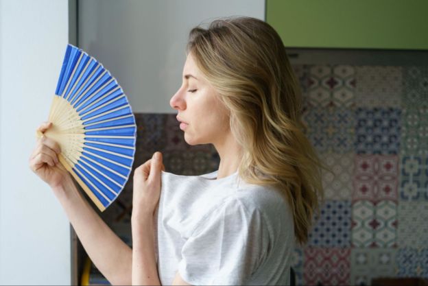 Woman using handheld fan
