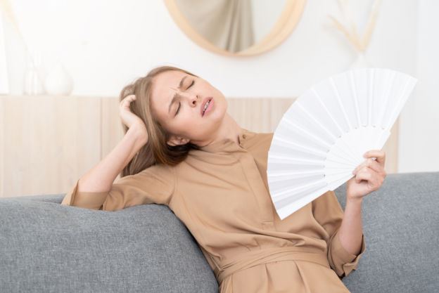 Woman Fanning Herself with Handheld Fan 