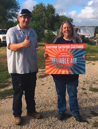 Happy customer holding up sign with a team member 