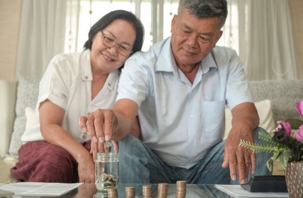 Couple Saving Money in a Coin Jar 